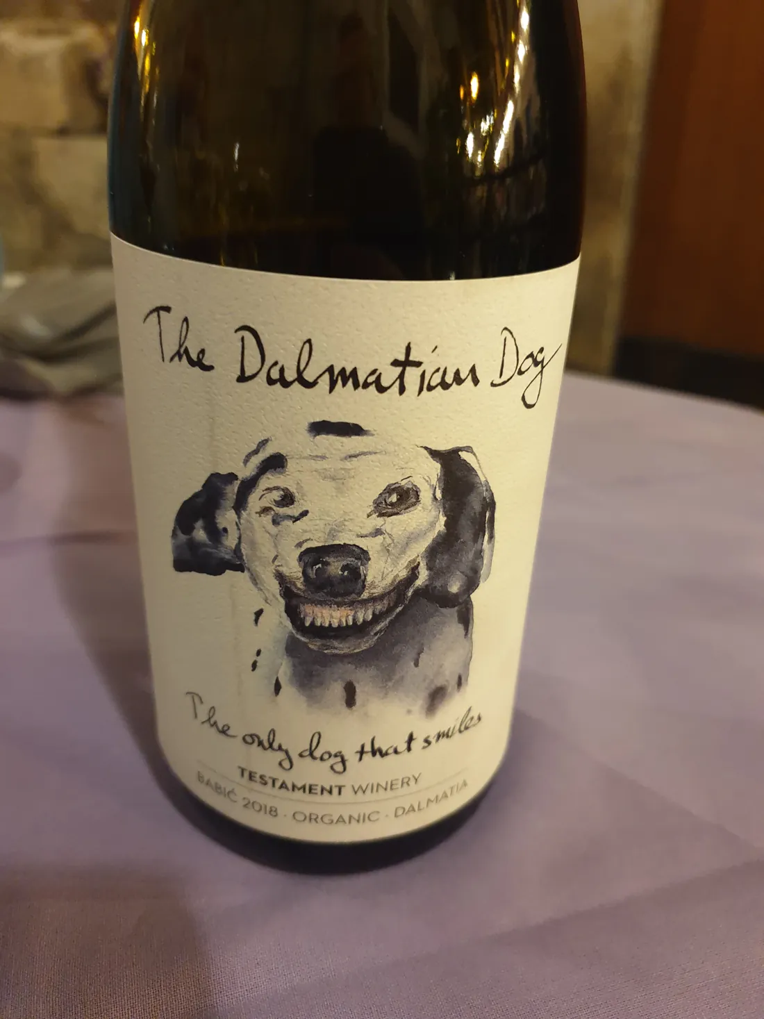 A bottle of local Dalmatian wine on a restaurant table by the sea at dusk