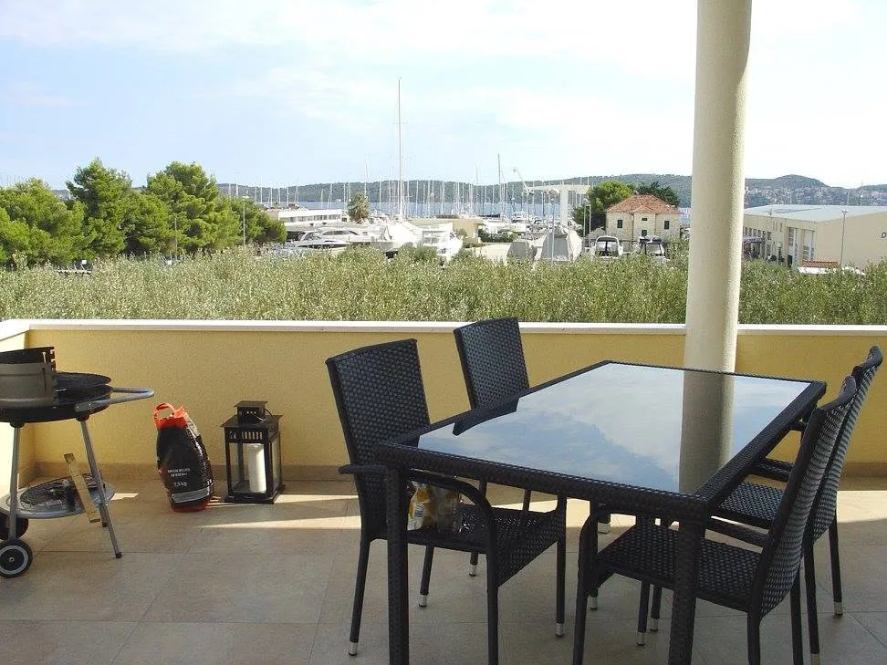 Sea-view terrace with dining table and barbecue at the one-bedroom Mornari Apartment 1 in Seget Donji
